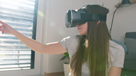 Girl-wearing-a-VR-headset,-moving-her-hand-on-the-VR-screen,-handheld-shot